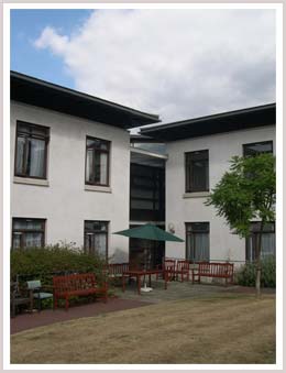 An image of sheltered housing with benches outside in the garden 